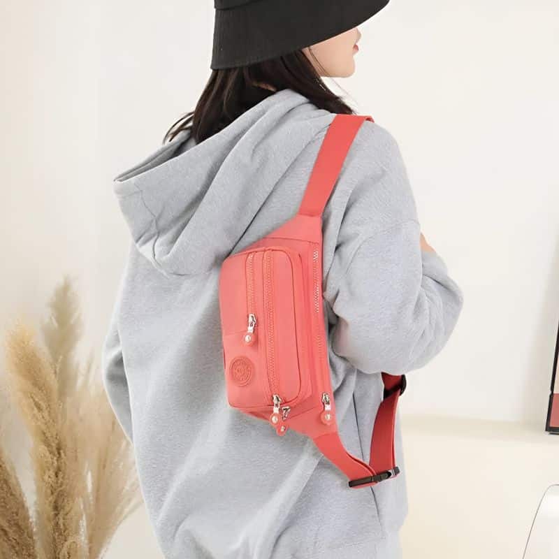 pink multi-pocket fanny pack on the shoulder